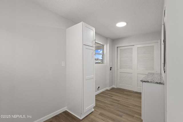 hall with wood-type flooring and a textured ceiling