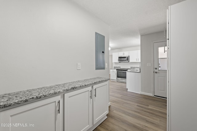 kitchen with light stone counters, appliances with stainless steel finishes, a textured ceiling, and white cabinets