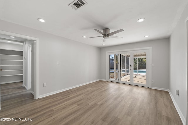 empty room featuring wood-type flooring, french doors, and ceiling fan