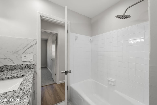 bathroom with vanity, hardwood / wood-style flooring, and washtub / shower combination