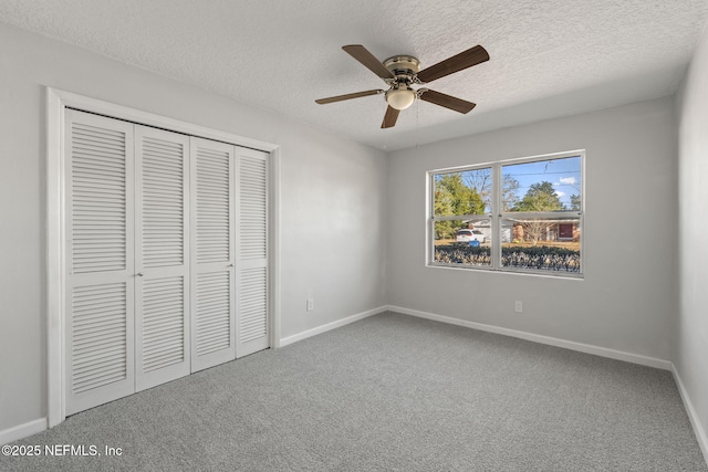 unfurnished bedroom featuring carpet, a textured ceiling, ceiling fan, and a closet