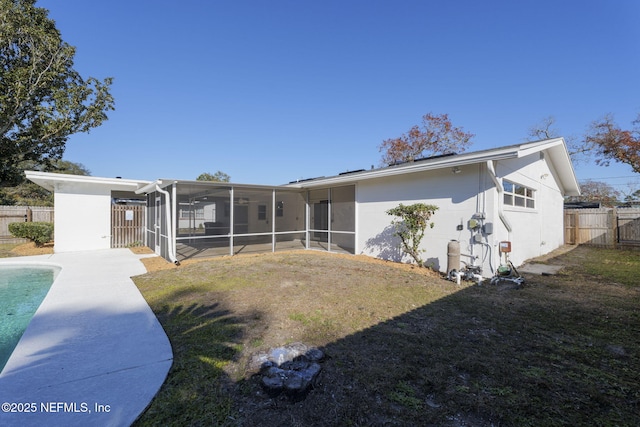 back of property with a sunroom and a lawn