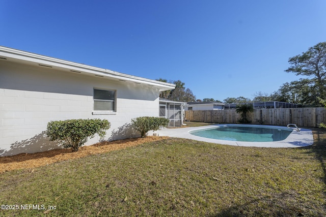 view of swimming pool with a yard and a sunroom