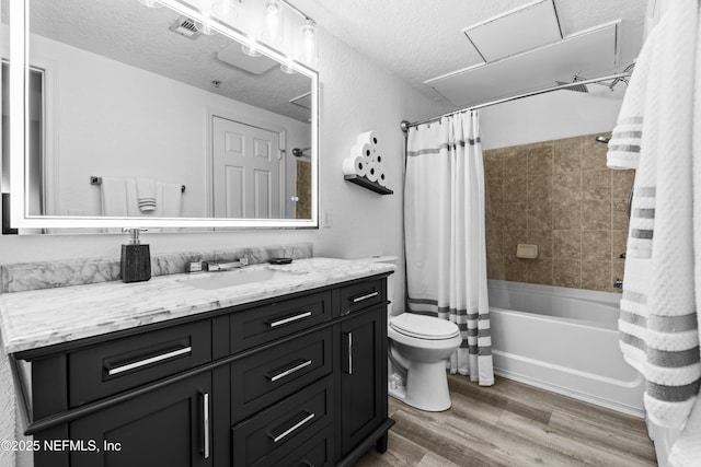 full bathroom featuring a textured ceiling, vanity, toilet, shower / tub combo with curtain, and hardwood / wood-style flooring