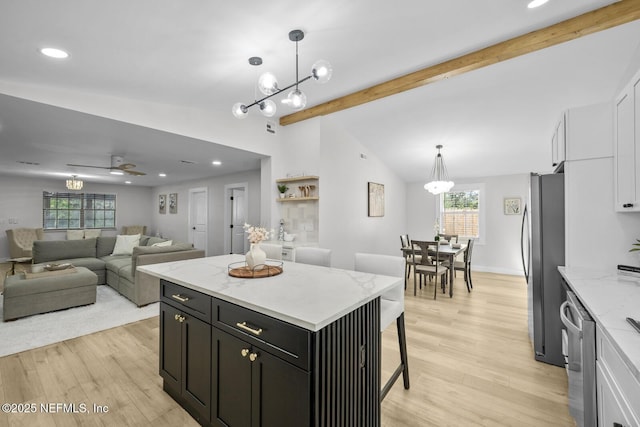 kitchen with hanging light fixtures, white cabinetry, appliances with stainless steel finishes, and a center island