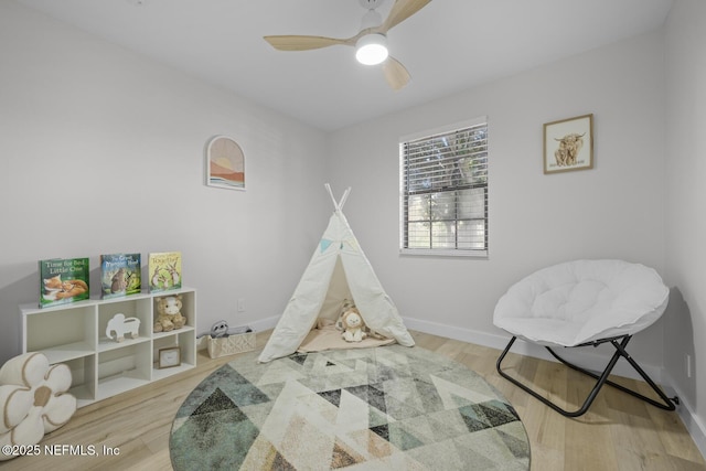 recreation room with light hardwood / wood-style floors and ceiling fan