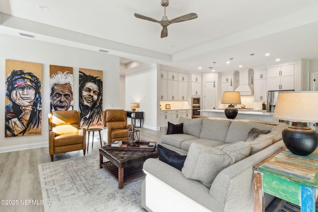 living room featuring light hardwood / wood-style flooring and ceiling fan