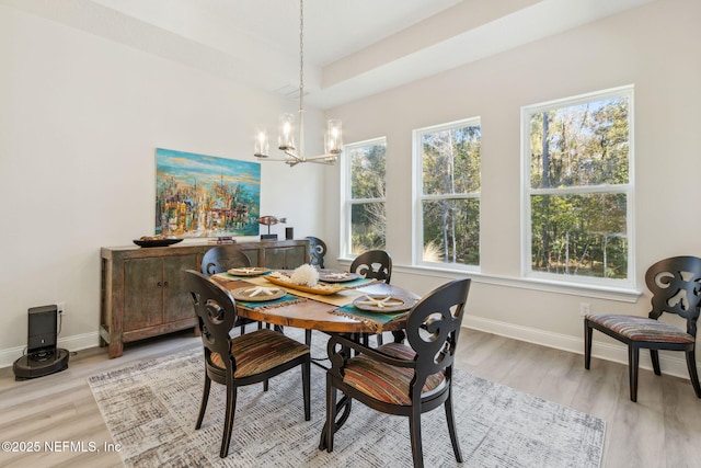 dining area featuring light hardwood / wood-style flooring and a notable chandelier