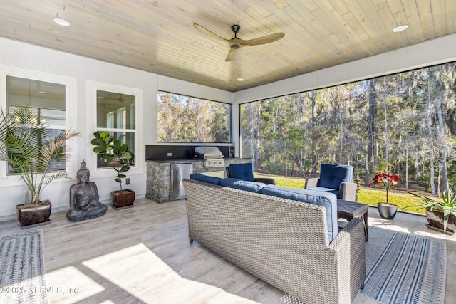 sunroom with ceiling fan and wooden ceiling