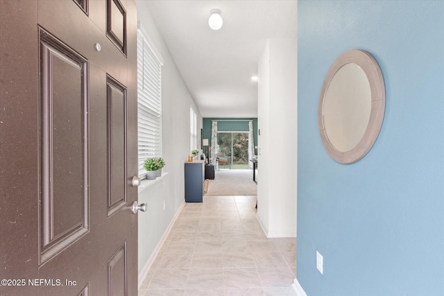 hall with light tile patterned floors