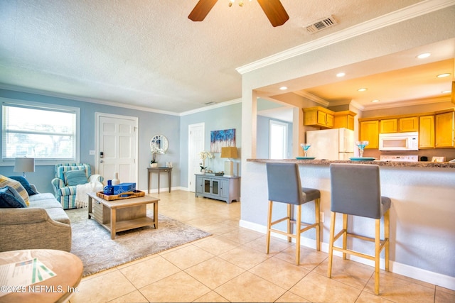 living room with light tile patterned floors, crown molding, a textured ceiling, and ceiling fan