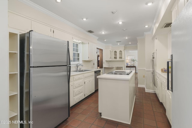 kitchen featuring sink, crown molding, appliances with stainless steel finishes, white cabinetry, and a kitchen island