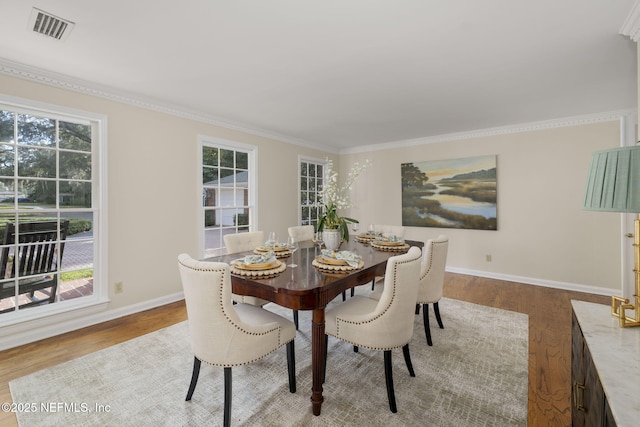 dining room featuring ornamental molding and light wood-type flooring