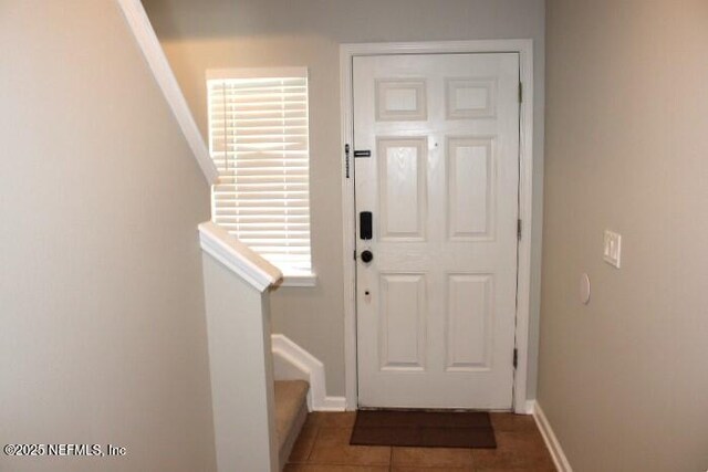 entryway with dark tile patterned floors