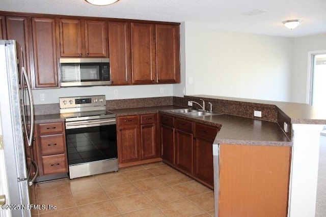 kitchen with stainless steel appliances, kitchen peninsula, sink, and light tile patterned floors