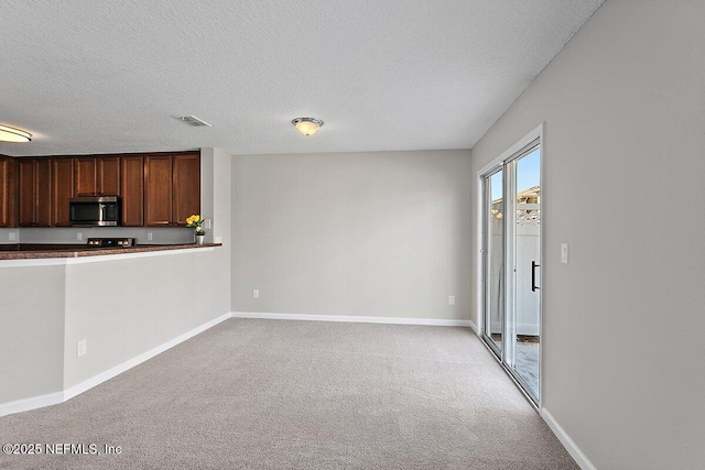 unfurnished living room featuring light carpet and a textured ceiling