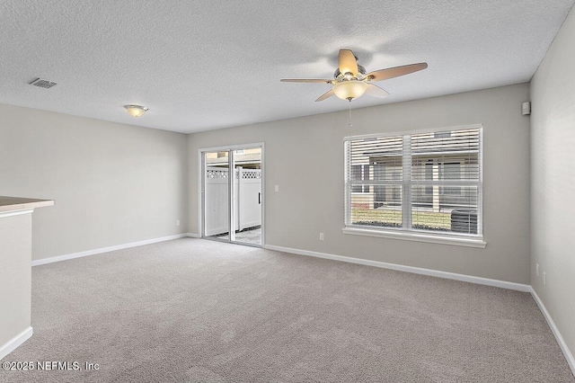 spare room with light carpet, a textured ceiling, and ceiling fan