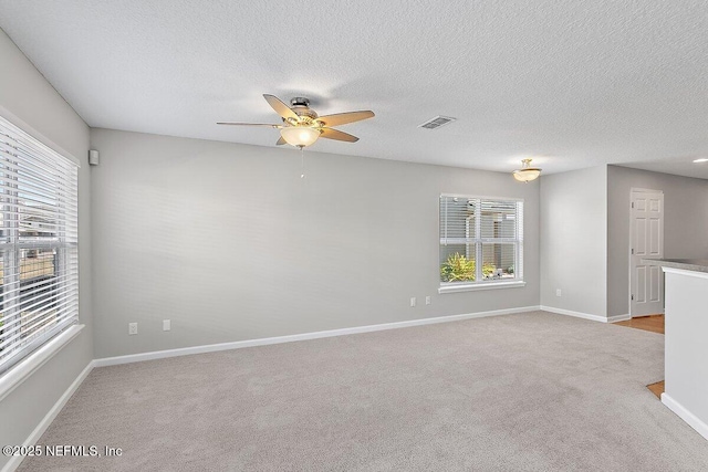 carpeted empty room featuring a textured ceiling and ceiling fan