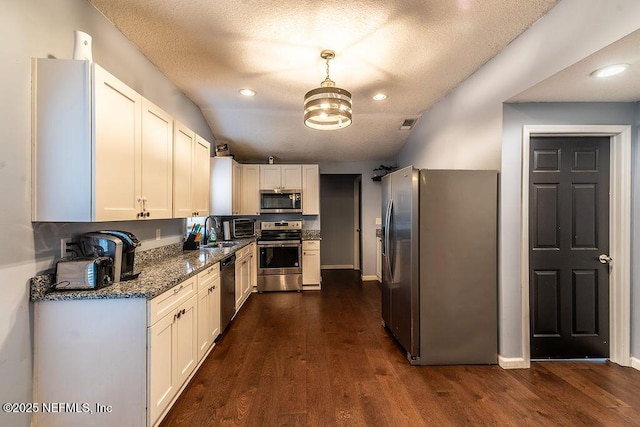 kitchen featuring a textured ceiling, white cabinetry, stainless steel appliances, dark stone counters, and sink