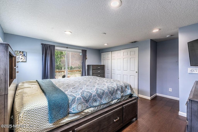 bedroom featuring a closet, a textured ceiling, access to outside, and dark hardwood / wood-style flooring