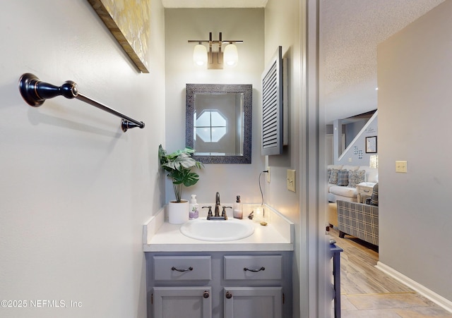 bathroom featuring hardwood / wood-style flooring, vanity, and a textured ceiling