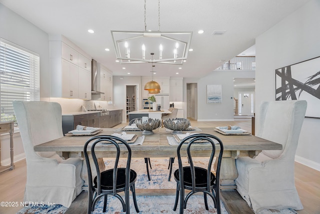 dining room featuring an inviting chandelier and light wood-type flooring