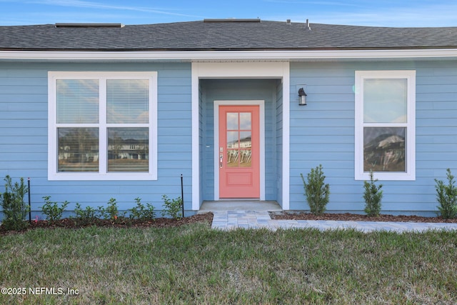 property entrance with a lawn