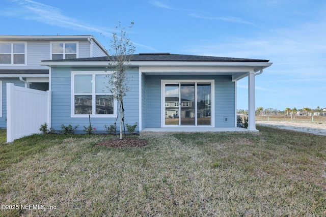 rear view of property featuring a lawn