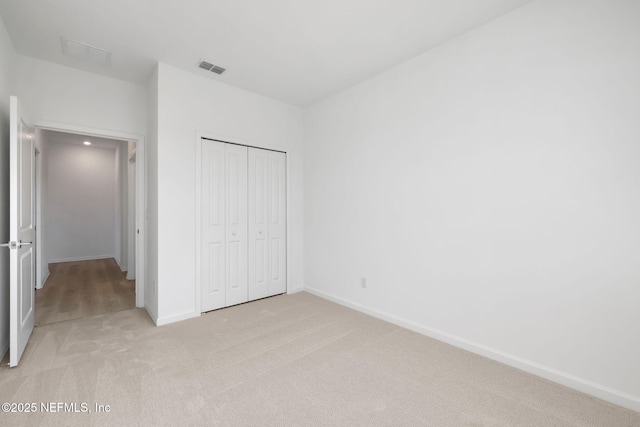 unfurnished bedroom featuring a closet and light carpet