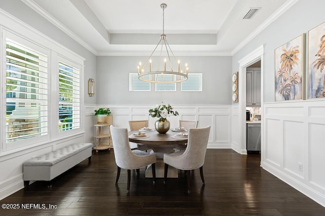 dining room with a tray ceiling, visible vents, dark wood-style floors, and a chandelier