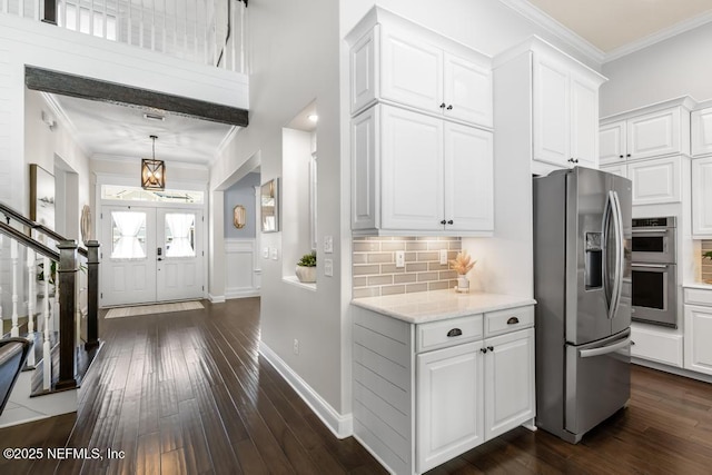 kitchen featuring ornamental molding, backsplash, dark wood-style floors, white cabinetry, and appliances with stainless steel finishes