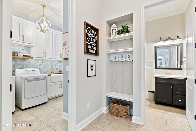 laundry area featuring washer / clothes dryer, cabinet space, light tile patterned floors, and a sink