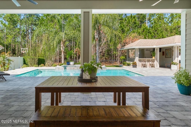 pool with outdoor dry bar, a patio area, and fence