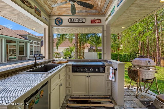 view of patio featuring a sink, ceiling fan, fence, grilling area, and an outdoor kitchen