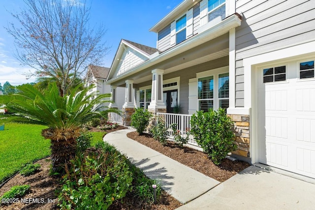 doorway to property with stone siding and a porch