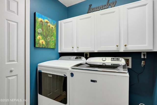 laundry area featuring washer and dryer, cabinets, and a textured ceiling