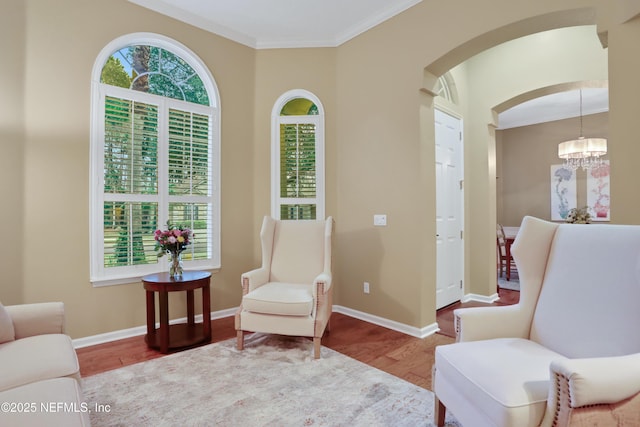 sitting room with ornamental molding, a chandelier, and light wood-type flooring