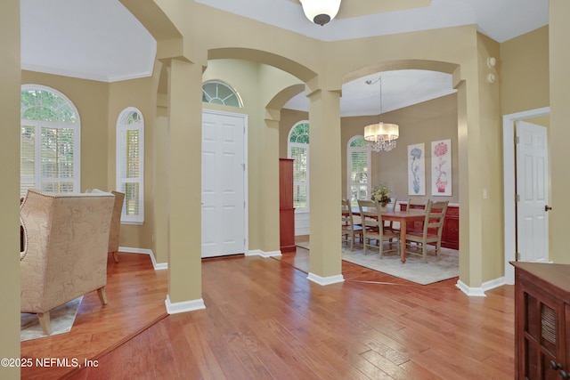 entryway with wood-type flooring and a notable chandelier