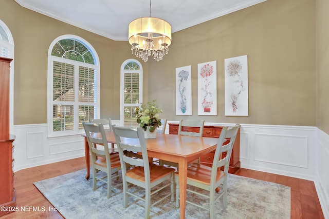 dining area with light hardwood / wood-style flooring, a notable chandelier, and ornamental molding