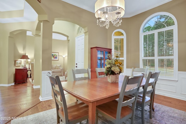 dining room with light hardwood / wood-style floors, crown molding, and a notable chandelier