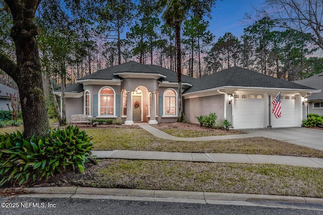 view of front of home featuring a garage and a yard