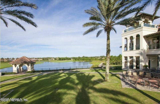 exterior space with a gazebo, a lawn, and a water view