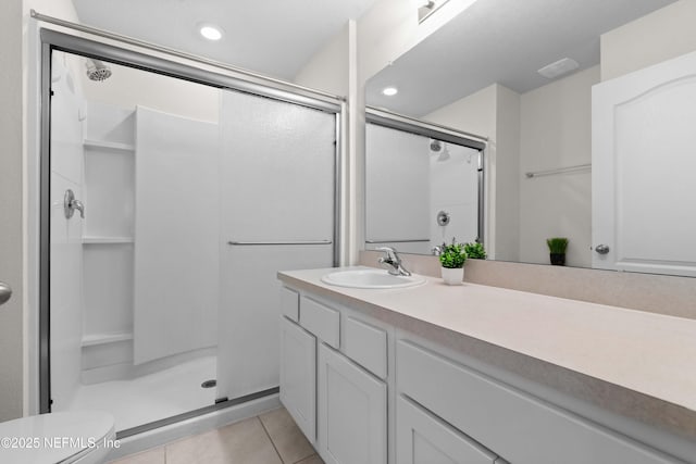 bathroom with vanity, toilet, tile patterned floors, and a shower with shower door