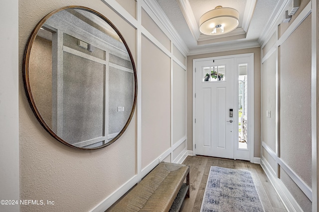 entrance foyer featuring crown molding and light wood-type flooring