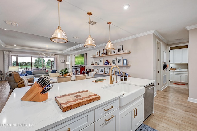 kitchen with white cabinets, a tray ceiling, sink, hanging light fixtures, and stainless steel dishwasher