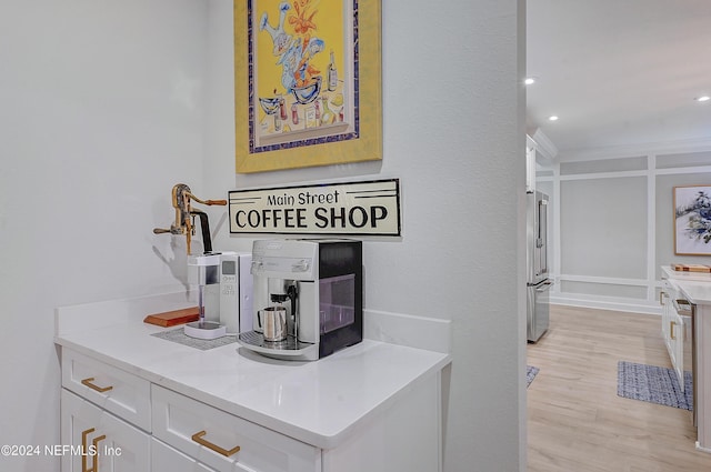 details with hardwood / wood-style floors, crown molding, and high end fridge