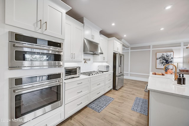 kitchen featuring sink, white cabinets, light hardwood / wood-style floors, and appliances with stainless steel finishes