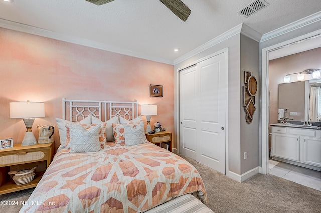 bedroom with light carpet, a closet, ensuite bathroom, and ornamental molding