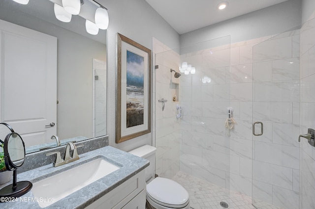 bathroom with vanity, toilet, and a shower with door