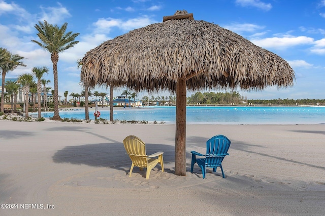 view of pool featuring a gazebo, a water view, and a view of the beach